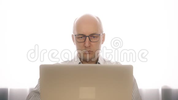 恼羞成怒的戴眼镜的商人担心突然的笔记本电脑故障告诉他这个人有问题视频的预览图