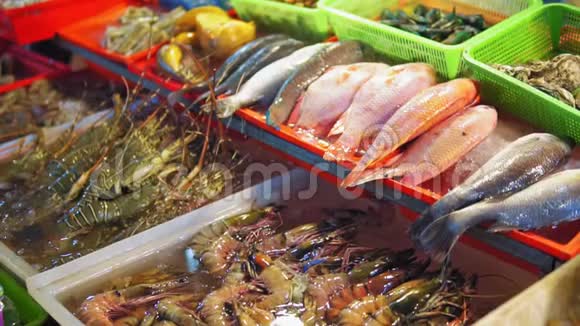 亚洲夜市海鲜街头美食柜台上的鱼虾龙虾螃蟹供旅客和视频的预览图