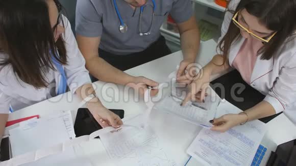 会见医生办公室诊所的桌子男医生和两名女医生正在处理文件视频的预览图