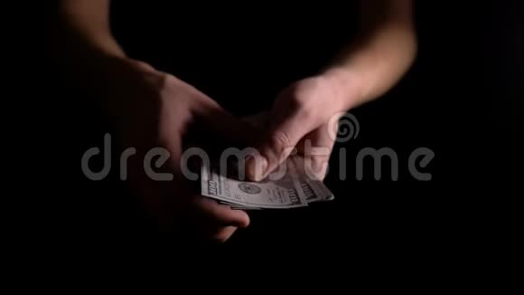 男人手在黑暗中数美元那个人数美元该员工以现金领取工资这笔费用视频的预览图