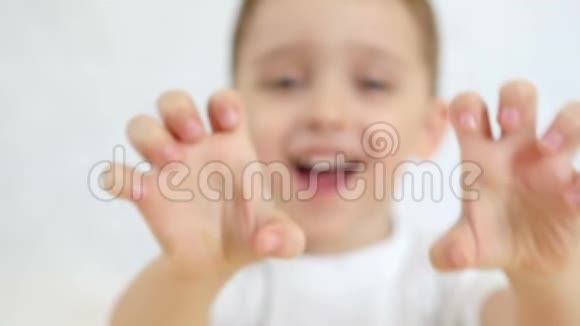 一个孩子很乐意在白色背景上展示他的双手特写视频的预览图