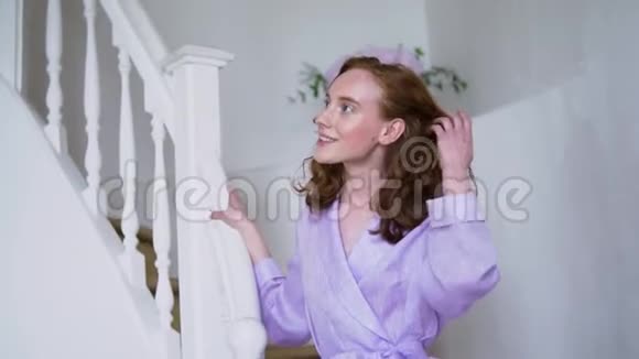穿着紫色西装站在白色梯子上为相机摆姿势的开朗积极的女孩视频的预览图