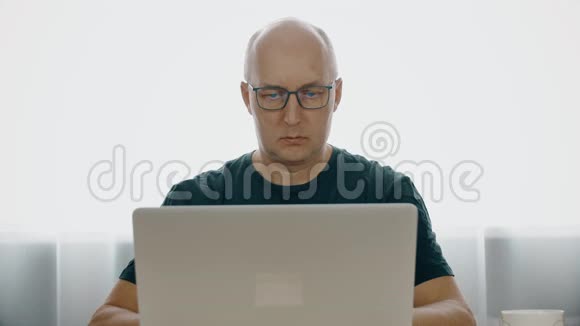 商务人员在家工作期间阅读笔记本电脑的文件资料视频的预览图