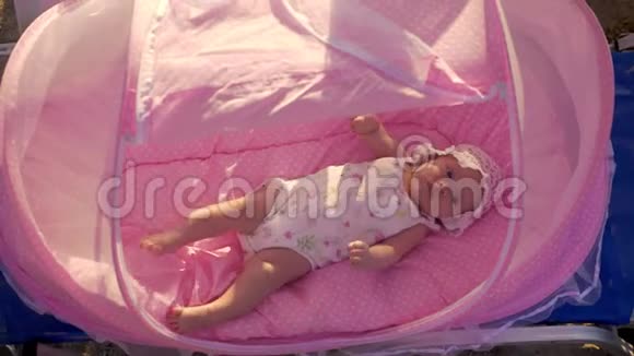沙滩上穿粉色摇篮的宝宝视频的预览图
