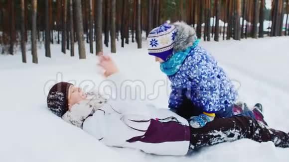 活跃的妈妈和女儿在冬天的森林里玩得很开心视频的预览图