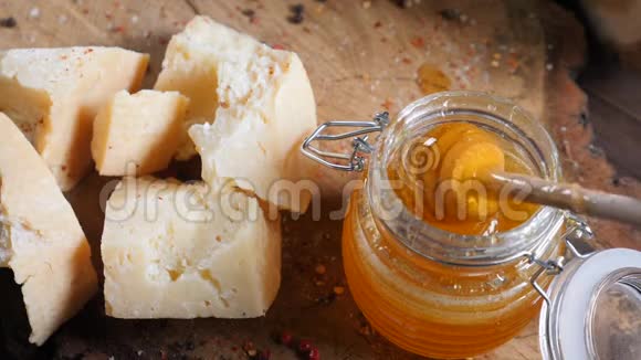 蜂蜜棒在女性手中缓慢运动各种各样的奶酪放在木制背景上餐厅的食物食品艺术视频的预览图