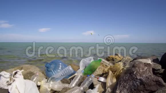 石头海滩上肮脏的塑料瓶环境污染视频的预览图