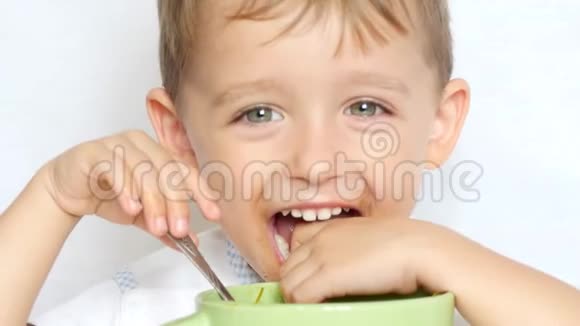 小男孩用勺子从盘子里吃汤特写视频的预览图
