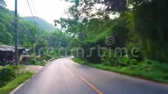 在热带亚洲的道路上驾驶沿着路线的棕榈树热带亚洲道路上的交通视频的预览图
