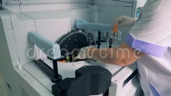 带有样品的唾液被放进分析机器里视频的预览图