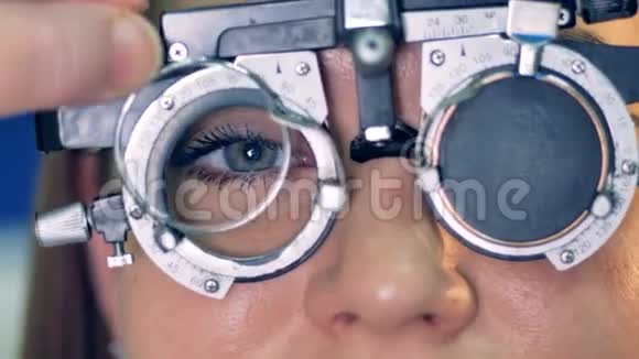 在光学试验框架后面的女性眼睛上的特写镜头视频的预览图