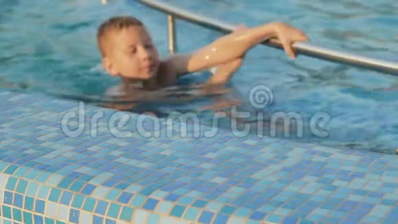 男孩游到池边微笑视频的预览图