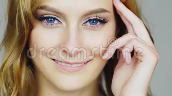 一个年轻的蓝眼睛女人的肖像与她的面部手指有关视频的预览图