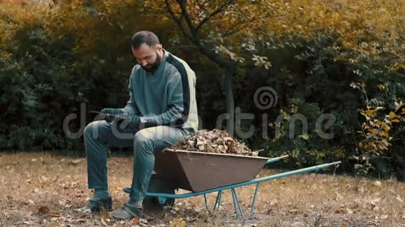 花园工作的人是一个从耙子里取出并清理干叶的人视频的预览图
