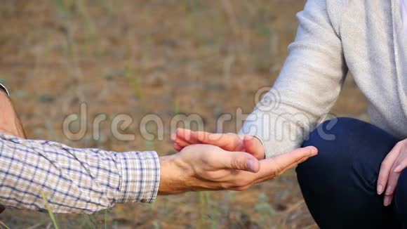 一对相爱的男人和女人在空中缓慢地握住他们的手女人手抚摸男人手视频的预览图