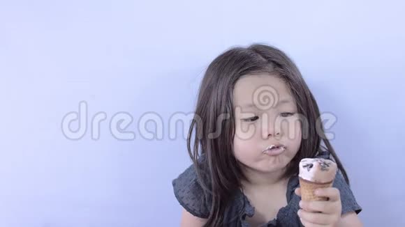 可爱的亚洲小女孩吃美味的冰淇淋视频的预览图