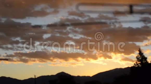 从屋顶缓慢移动的橙色和黄色日出云视频的预览图