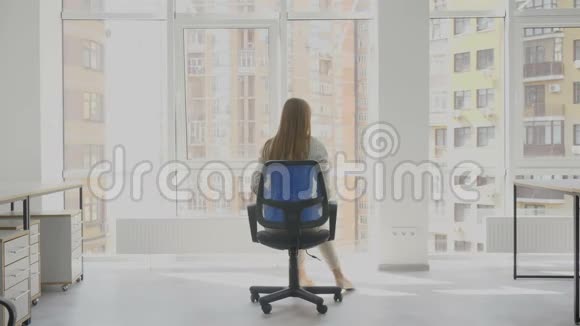 办公室工作人员年轻女子坐在椅子上手里拿着文件高兴地在椅子上转了一圈视频的预览图