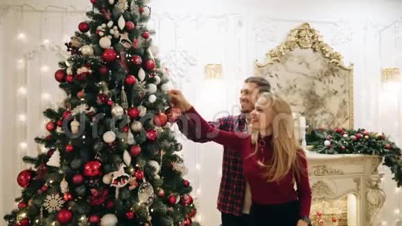 男孩和女孩装饰圣诞树把球掉了视频的预览图