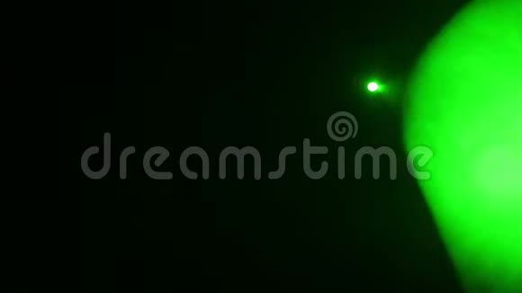 用烟雾机发出的烟雾中的聚光灯发出的一束绿光照亮场景视频的预览图