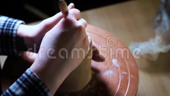 在陶工的车轮上用手捏紧粘土陶工用陶制工具在陶工身上塑造粘土制品视频的预览图