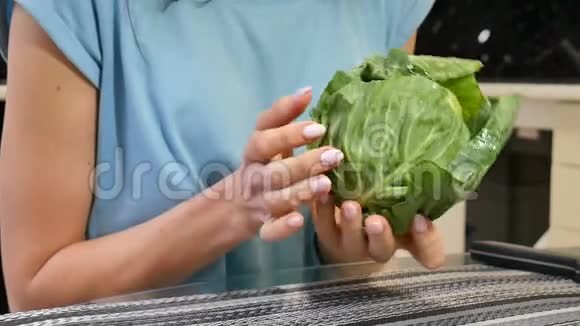 厨房里有绿色卷心菜的雌性手均衡的饮食观念视频的预览图