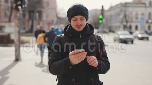 男人用智能手机在城市街道上行走视频的预览图
