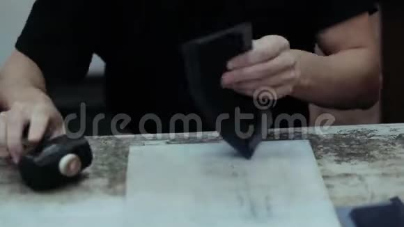 制作皮夹的大师手工锤打产品用刷子涂胶把一个主人关起来视频的预览图