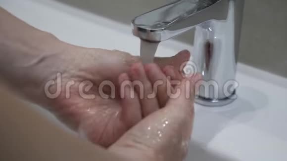一个女孩的特写她的手用水龙头里的水冲洗她的手慢动作视频的预览图