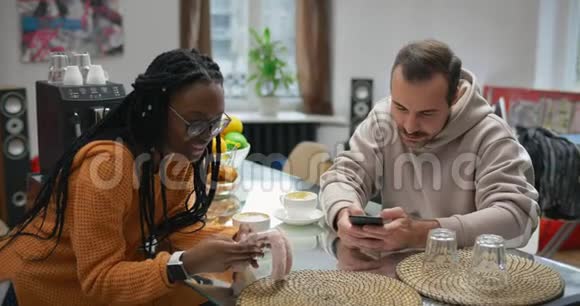 多种族夫妇早餐时使用手机社交媒体视频的预览图
