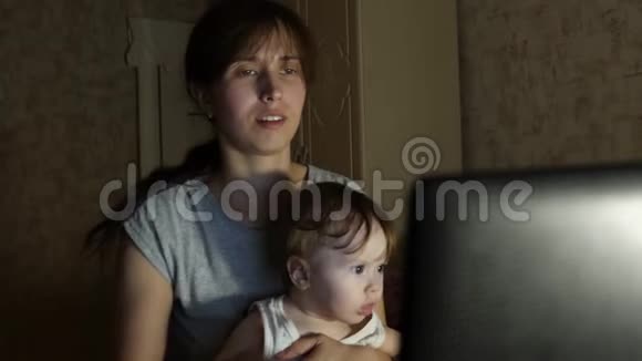 女商人深夜在电脑前工作膝盖上有个婴儿视频的预览图