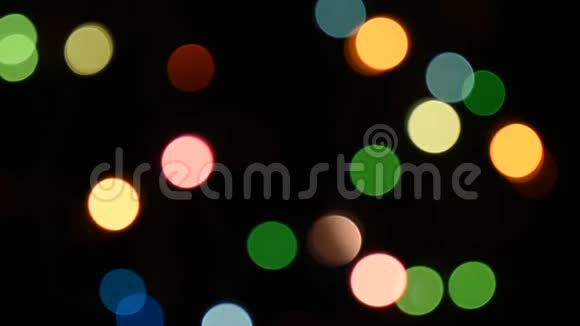 模糊的圆圈在黑暗的夜晚闪烁着五颜六色的光视频的预览图