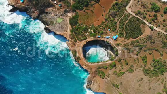 在努沙佩尼达岛上有蓝色海洋和海岸线的破碎海湾空中无人机视野视频的预览图