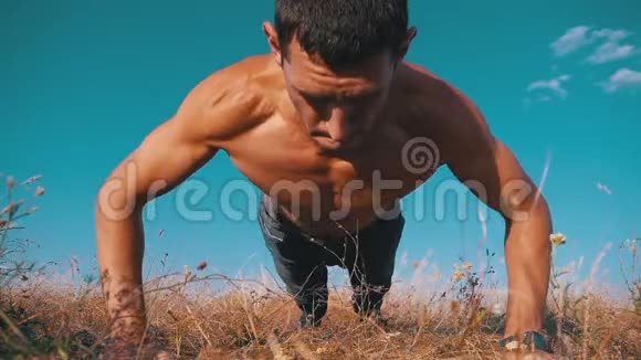 健身强壮的人做俯卧撑在外面拍自然慢动作视频的预览图
