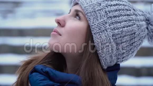 女人侧目望着冬日的天空年轻迷人的女人长相梦幻视频的预览图