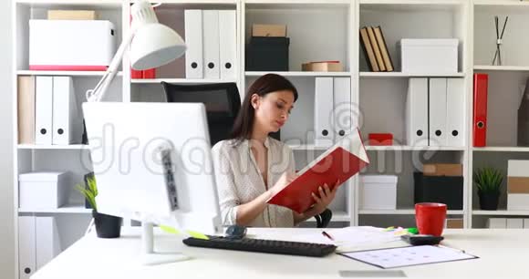 穿白色衬衫的女商人在文件夹里检查文件视频的预览图
