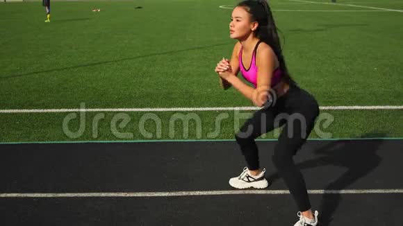 运动的年轻亚洲女人正在体育场上伸展户外运动视频的预览图