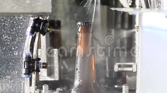 在传送带中清洗完整的啤酒瓶玻璃瓶厂工业生产线上的瓶子啤酒棕色玻璃瓶视频的预览图