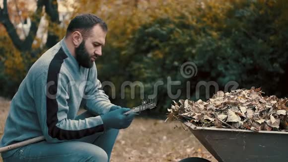 花园工作的人是一个从耙子里取出并清理干叶的人视频的预览图