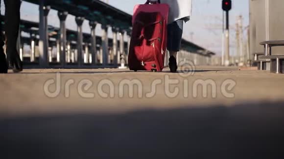 火车站的两个女孩带着手提箱在站台上等火车视频的预览图