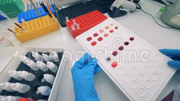 实验室的工作人员拿着调色板和血样视频的预览图
