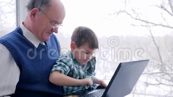 网上购物老人带着塑料卡孩子在家里通过笔记本电脑进行网上购物视频的预览图