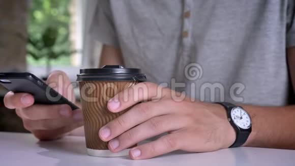 近镜头男人手里拿着咖啡在办公室打电话视频的预览图