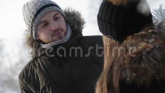 快乐的一对情侣在寒假期间一起在雪地公园里玩耍近距离观看视频的预览图