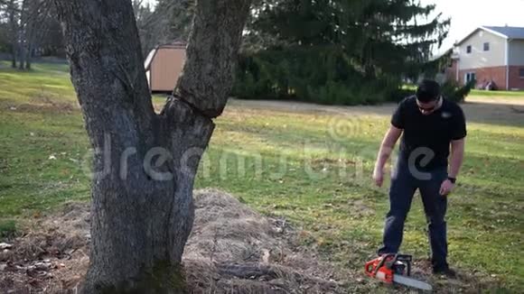 英俊的雇佣承包商准备用电锯砍倒一棵树视频的预览图