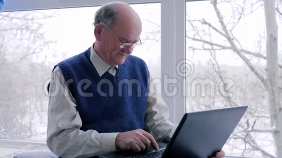 一对手提电脑的老夫妇周末在家一起休闲视频的预览图