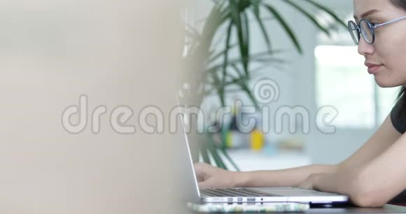 漂亮女人在家里工作的多莉移动手机和笔记本电脑在一个轻盈和自然的环境视频的预览图