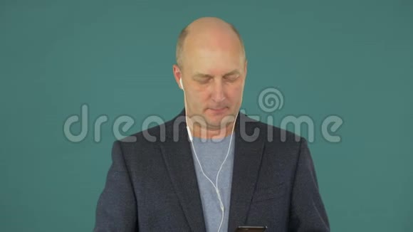 使用智能手机听耳机音乐的成年男子视频的预览图