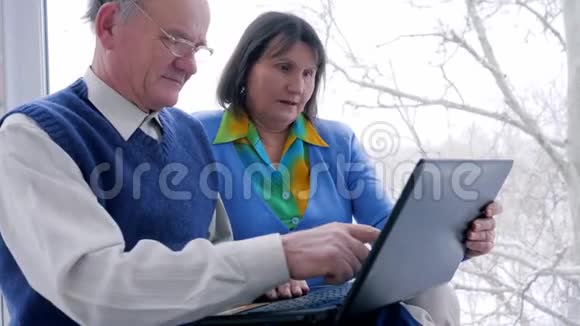 幸运的老夫妇带着信用卡和电脑上网购物视频的预览图
