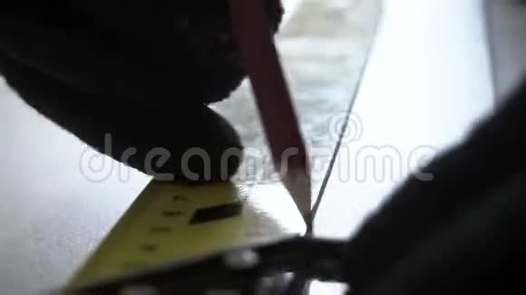 用一支铅笔和一把量尺用一双黑色手套为人主人的手做记号这是一个切割的地方视频的预览图